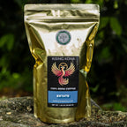 Gold coffee bag with a label on a stone surface with greenery in the background