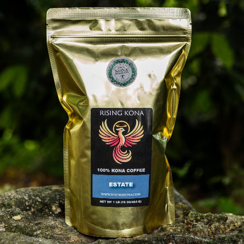 Gold coffee bag with a label on a stone surface with greenery in the background