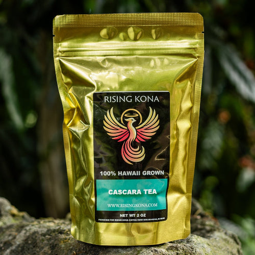 Gold package of coffee on a rock with coffee plants in the background